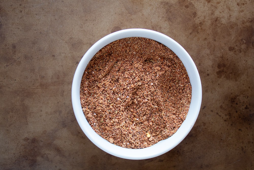 keto taco seasoning in a white bowl on a distressed serving tray