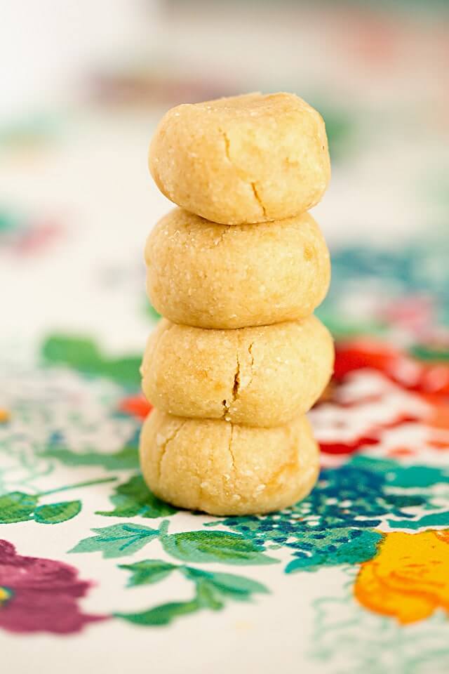 four keto cookies bites stacked on a floral towel