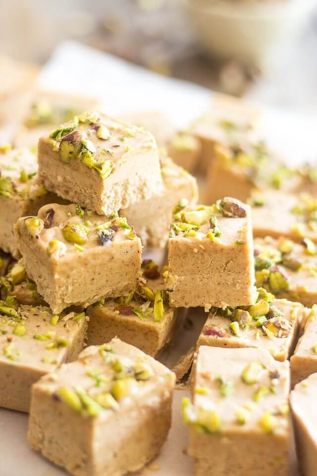 a stack of squares of fat bombs with pistachios on top