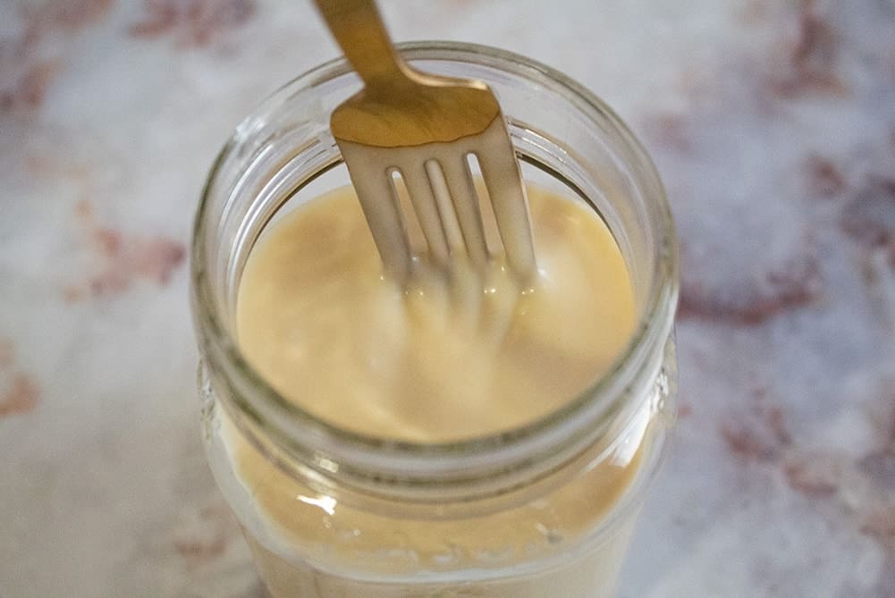 overhead view of fork inside jar full of keto sweetened condensed milk
