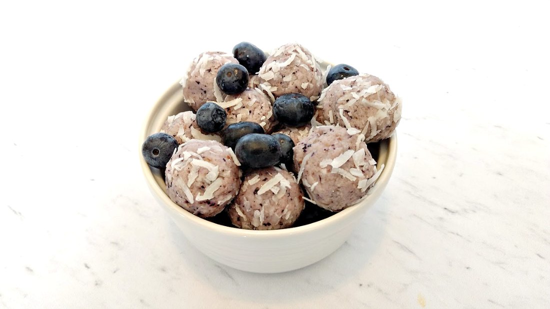 blueberry keto fat bombs in a white bowl on a white countertop