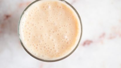 salted caramel keto smoothie in a clear glass on countertop