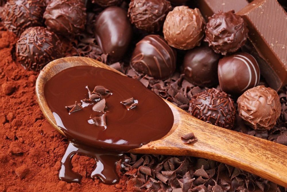 chocolate fat bombs next to a spoon of melted chocolate