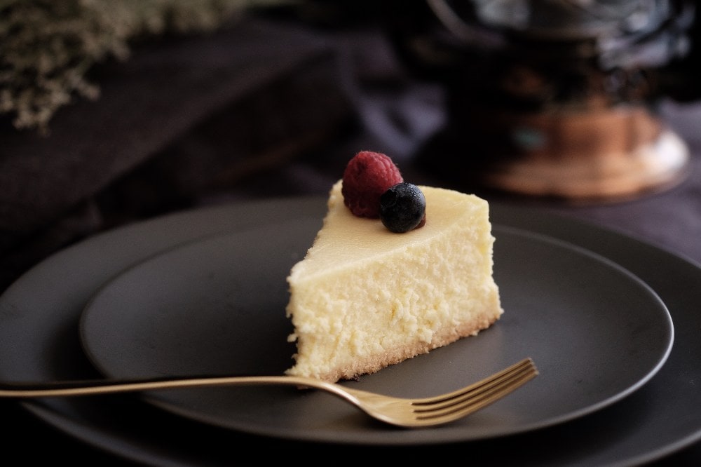 small slice of keto cheesecake on a charcoal plate