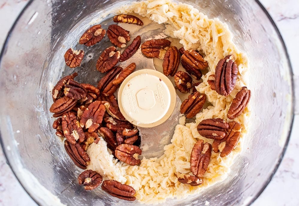 keto butter mixed with toasted pecans inside a food processor bowl