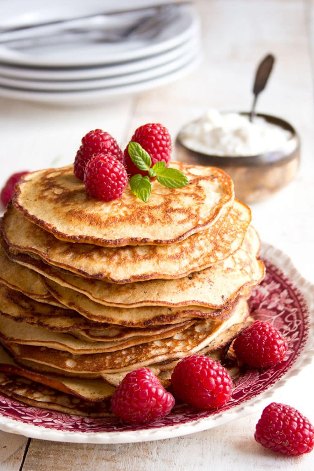 Keto Breakfast stack of pancakes with raspberries on top served on a dish