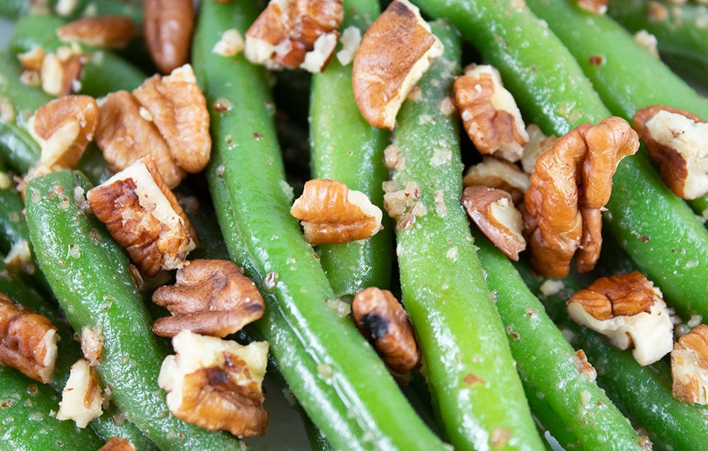 closeup of maple pecan green beans with crushed pecans on top