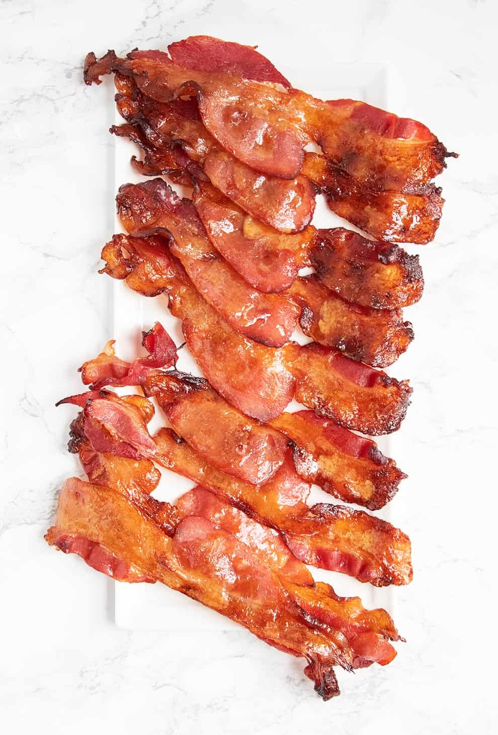 keto candied bacon laid down on a white plate in strips