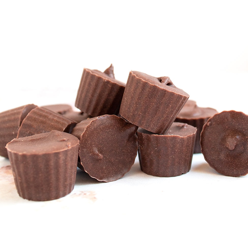 stack of chocolate fat bombs on a white background and white countertop