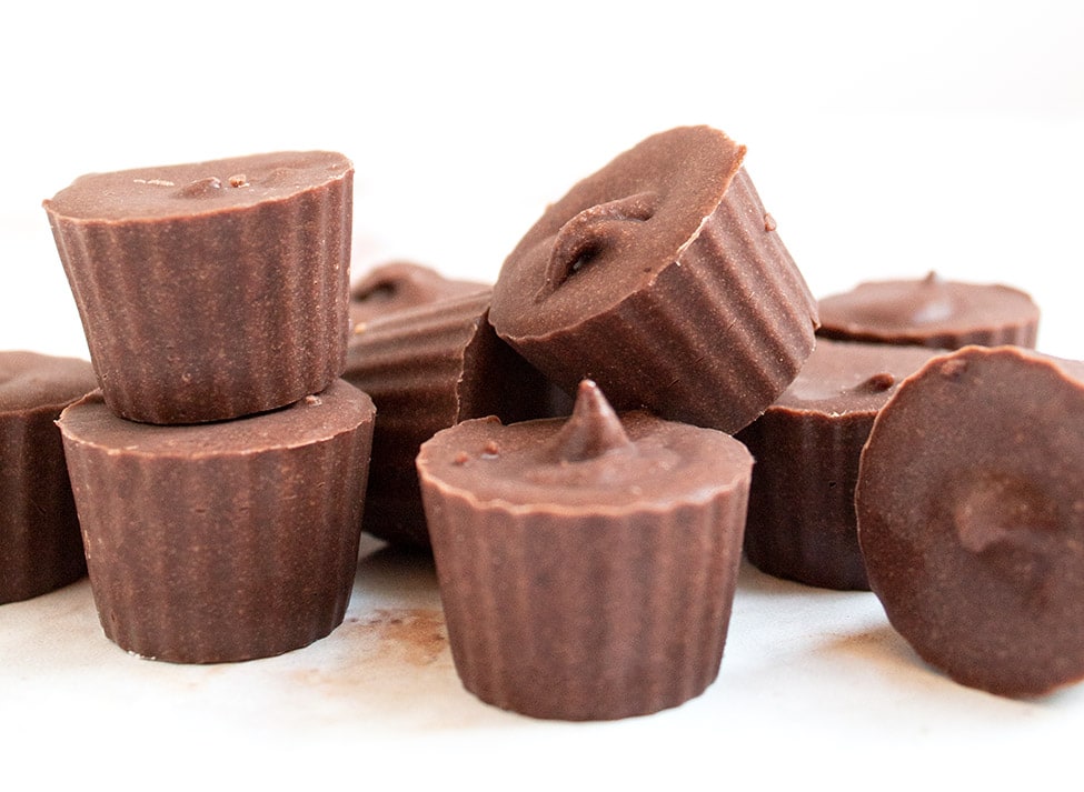 chocolate fat bombs stacked up on top of each other with white background