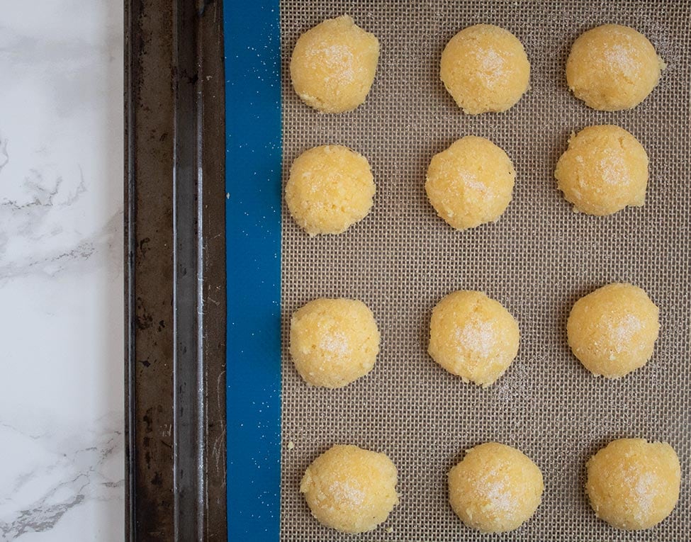 keto macaroons in a silicone baking mat on a baking sheet