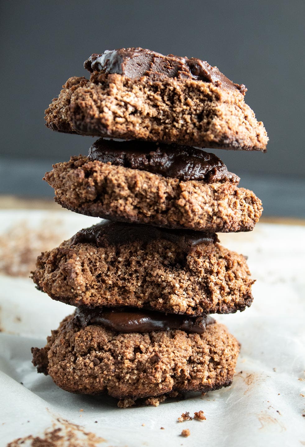 four chocolate keto cream cheese cookies stacked on top of each other