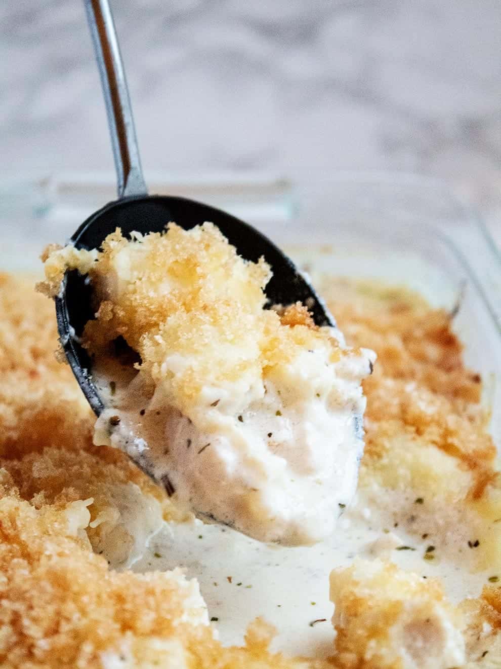 keto chicken alfredo casserole with a large black spoon dipped into the dish