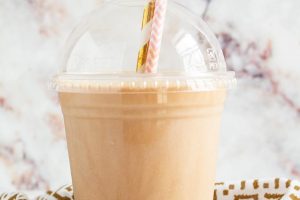 keto frappuccino keto iced coffee in a plastic cup with two decorative straws sticking out