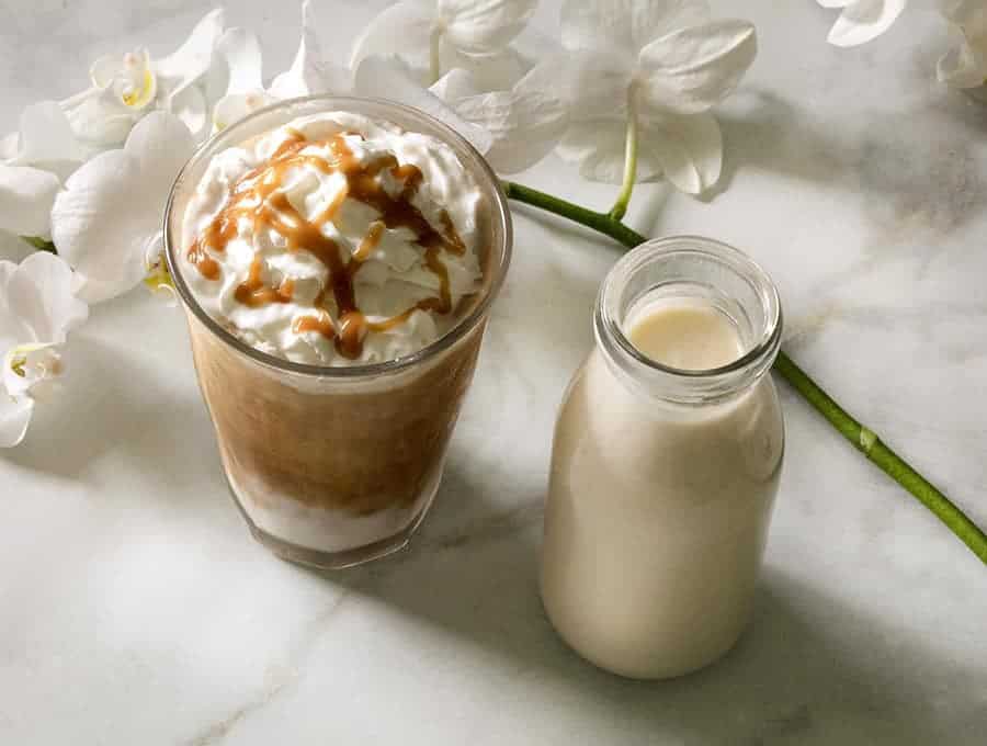 keto iced coffee in two glasses next to white flowers on a table