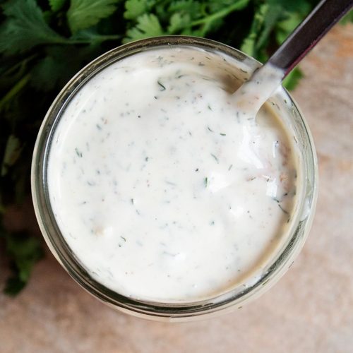 overhead view of creamy keto ranch dressing in a glass jar