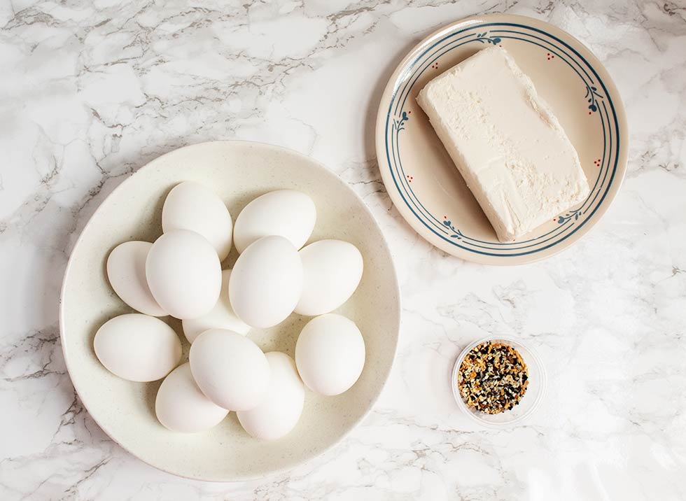 overhead view of keto deviled eggs ingredients including cream cheese and seasoning in a small bowl