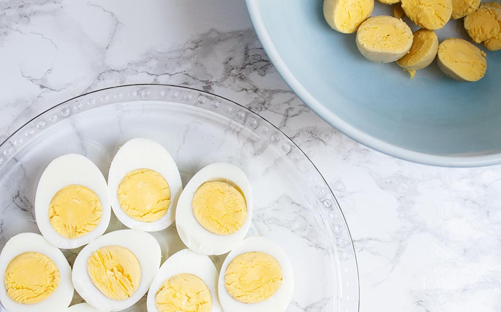 eggs with some yolks removed in a bowl to be used in keto deviled eggs