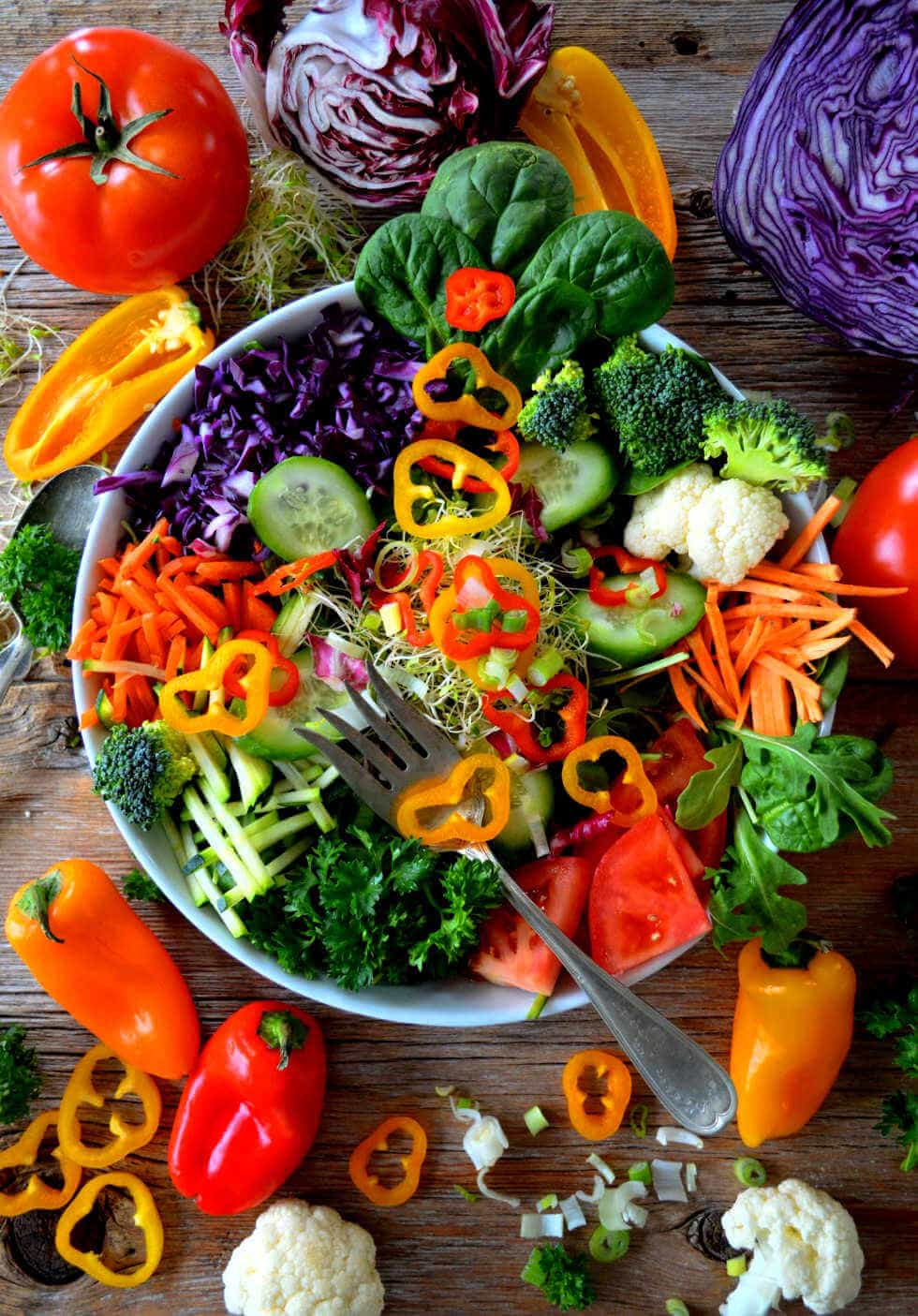 beautiful keto salad dressing photo with bowl overflowing with fresh vegetables