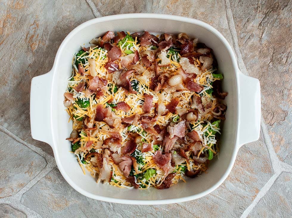 birdseye view of ingredients layered on top of fresh broccoli in a dish