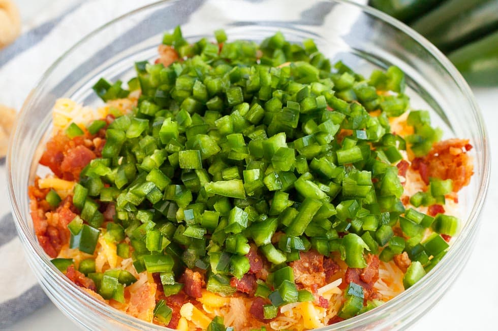 bowl containing bright vegetables and cheese for keto jalapeno popper dip