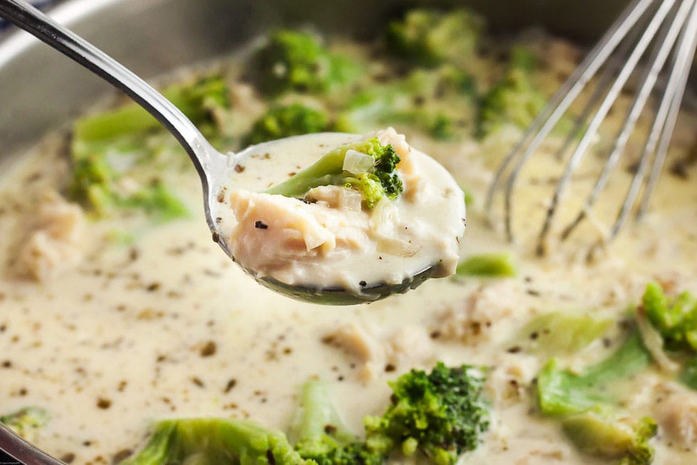 spoon containing keto chicken alfredo soup with soup pot in background