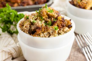side view of keto sausage stuffing in white stacked bowls by parsley
