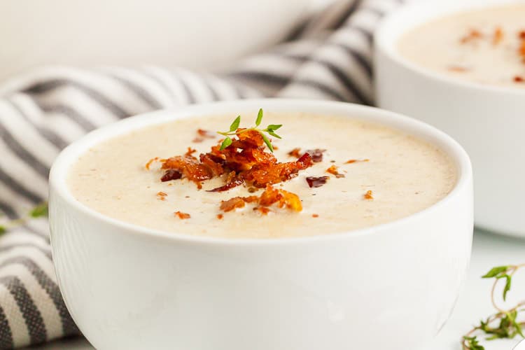 keto cauliflower soup inside bowl with bacon on top
