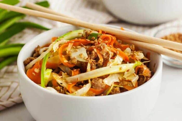keto egg roll in a bowl closeup view with chopsticks sitting on top as an example of keto dinners under 5g net carbs