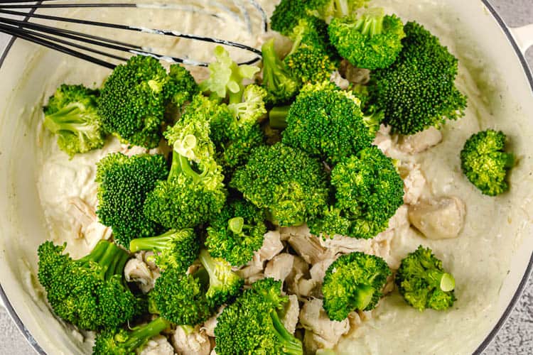 overhead view of dish containing broccoli, chicken breast, and cheese sauce