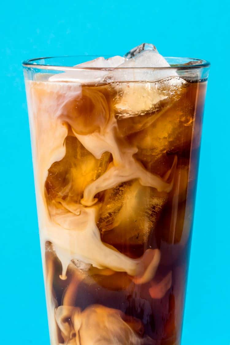 a large glass of keto iced coffee on a blue background