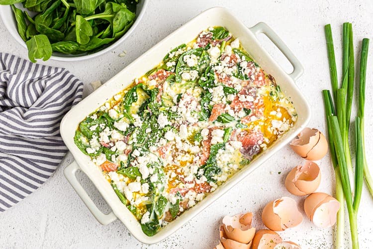 overhead view of keto breakfast casserole ingredients unbaked in a white dish