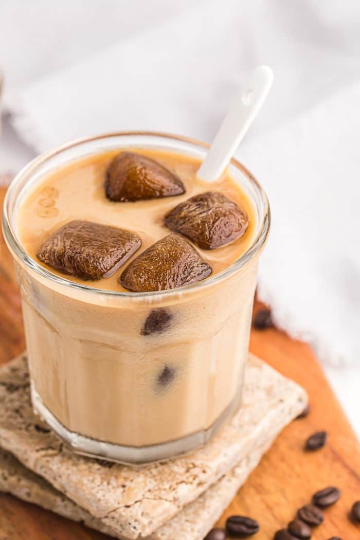 side view of glass of keto iced coffee with cubes melting in milk