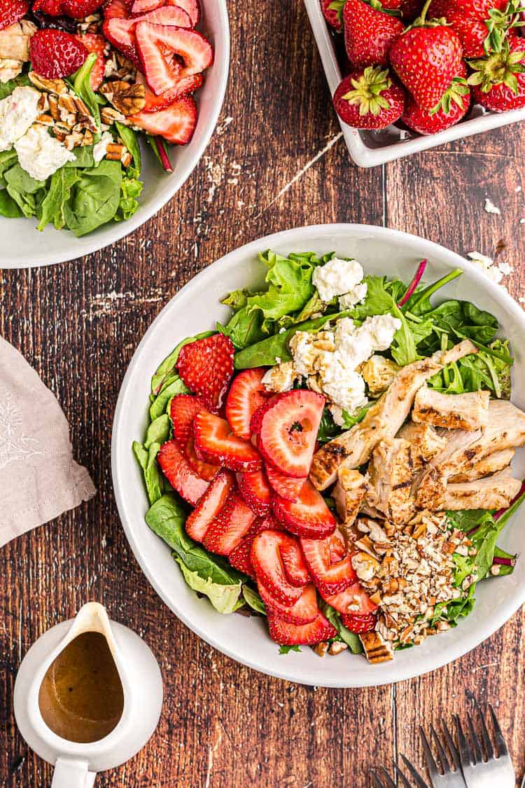 overhead view of keto strawberry chicken salad next to a bowl of fresh strawberries