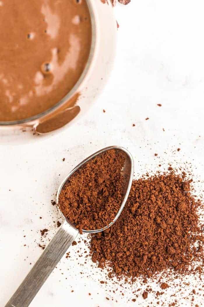 instant coffee granules on a spoon next to a smoothie