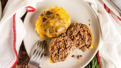 white plate containing two keto meatloaf muffins with cheese on top