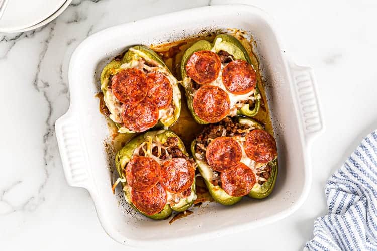 overhead view of fully cooked stuffed peppers keto in white baking dish