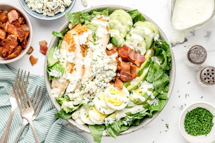 overhead view of large bowl containing low carb cobb salad with dressing drizzled on top