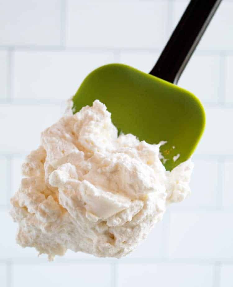 green spatula containing keto whipped cream