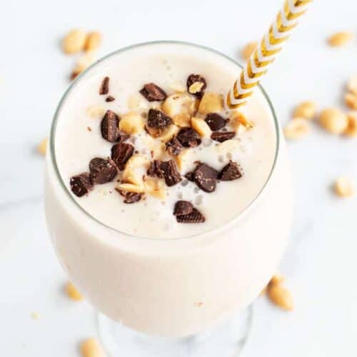keto peanut butter smoothie in a glass with gold and white straw