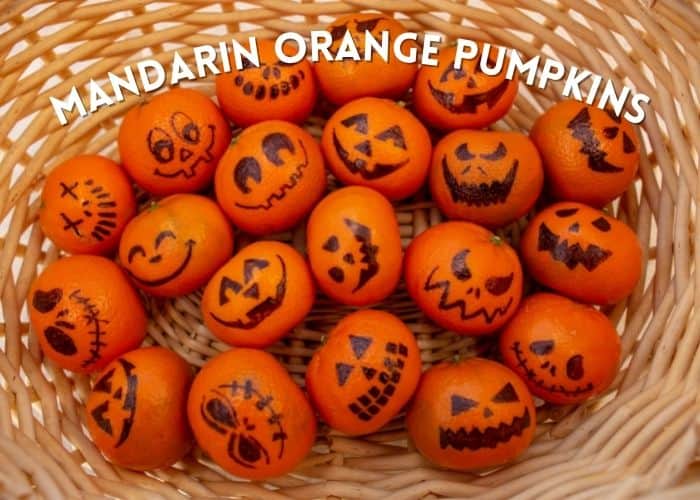 mandarin oranges with pumpkin faces in a basket