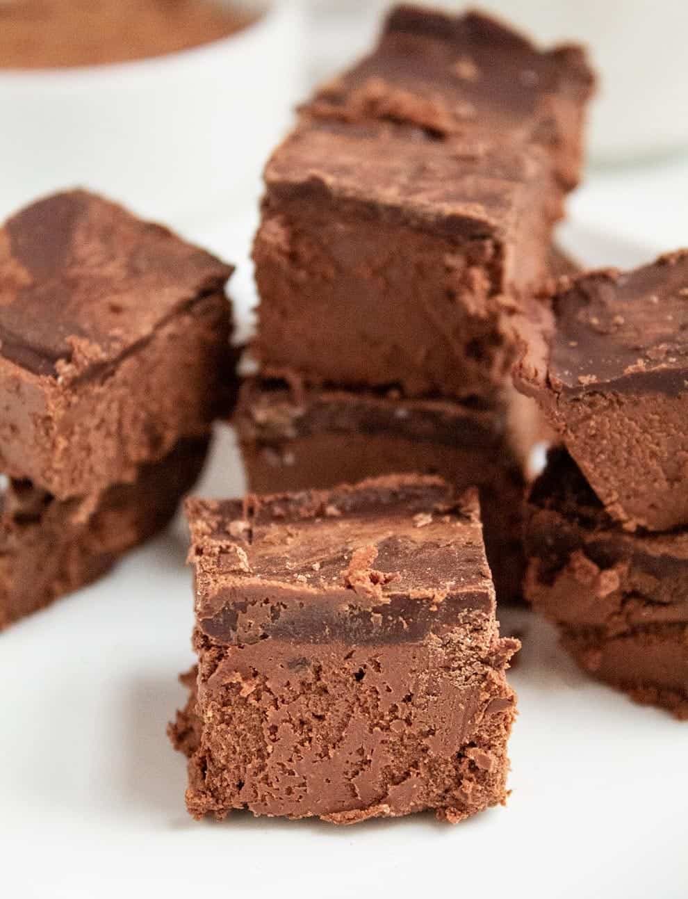 keto chocolate dessert on a white plate with cocoa powder in a white bowl