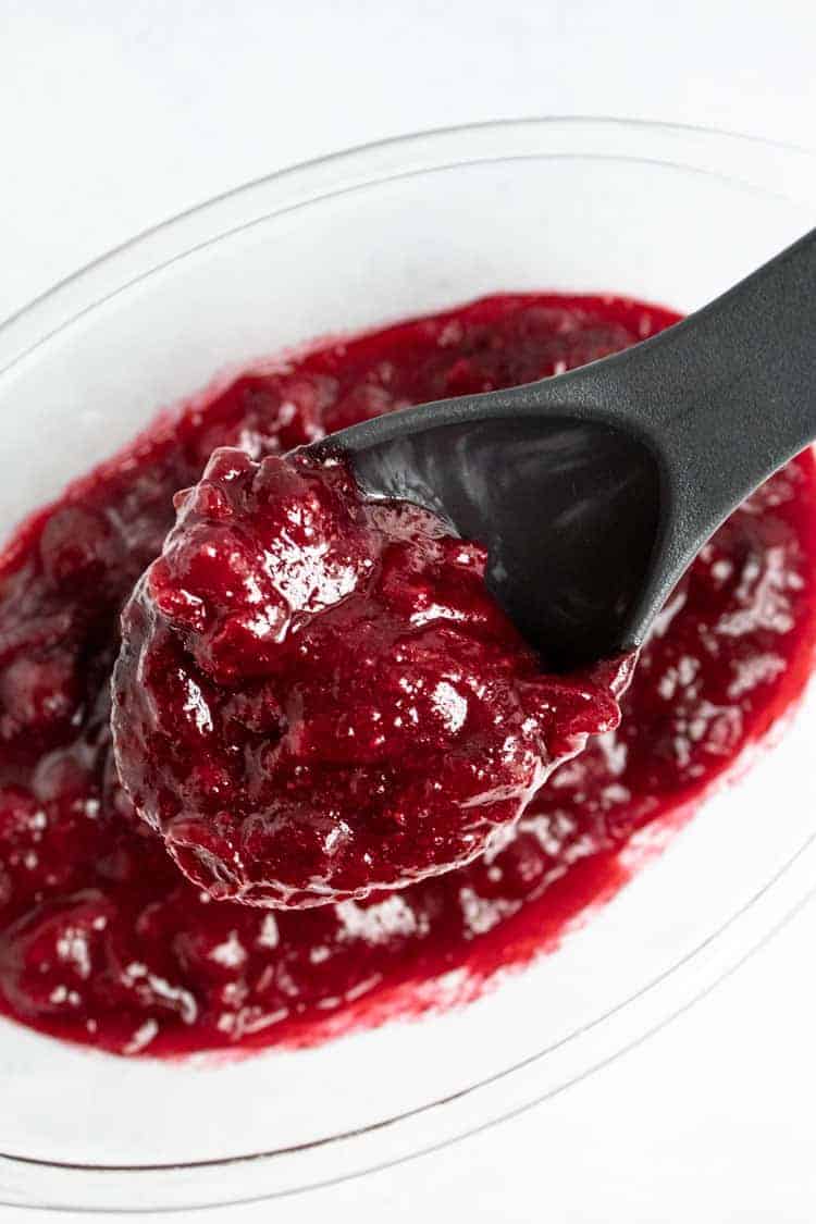 keto cranberry sauce in bowl with serving spoon over bowl to serve