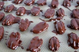 closeup of chocolate covered pecans with several broken in half