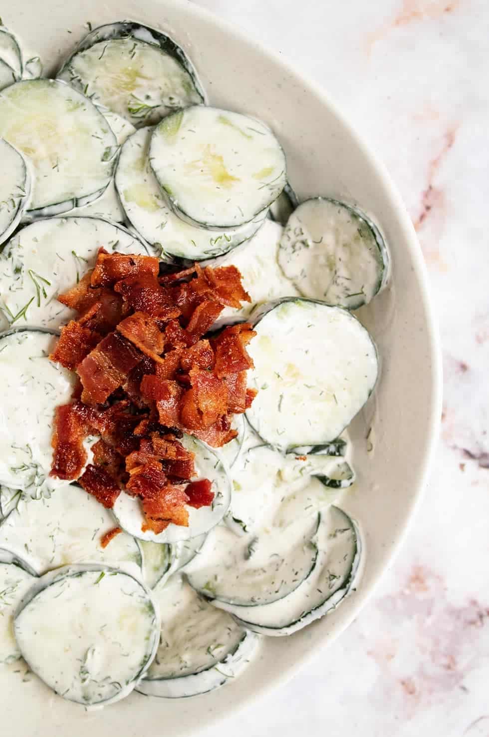 overhead view of keto cucumber salad with crumbled bacon on top