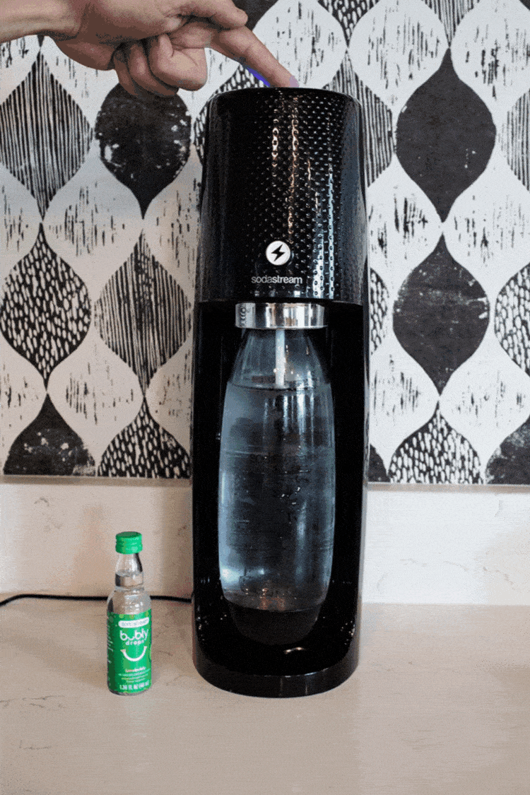 sodastream being operated by hand pressing button