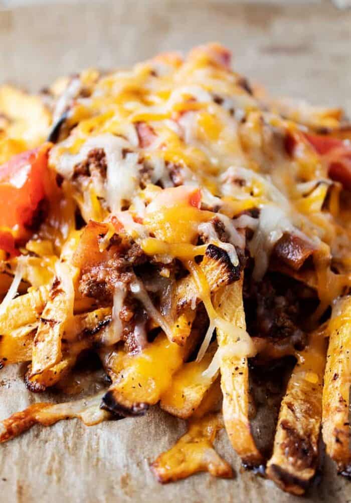 closeup of keto chili cheese fries on a baking sheet with parchment paper