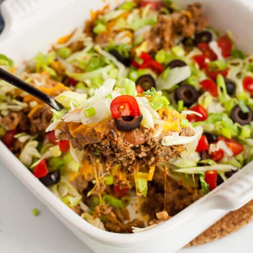 white casserole dish with spoon scooping out low carb taco casserole piece