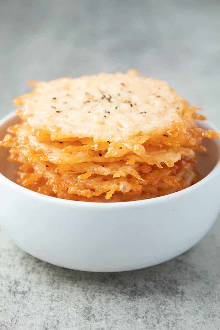 stack of parmesan crisps inside of white bowl