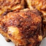 sideview of 3 pieces of air fryer chicken thighs cripsy and ready to serve on a white marble surface